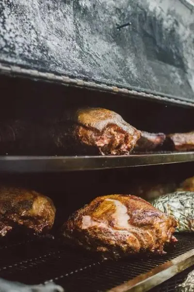 Meat cooks on a multi-tiered barbecue
