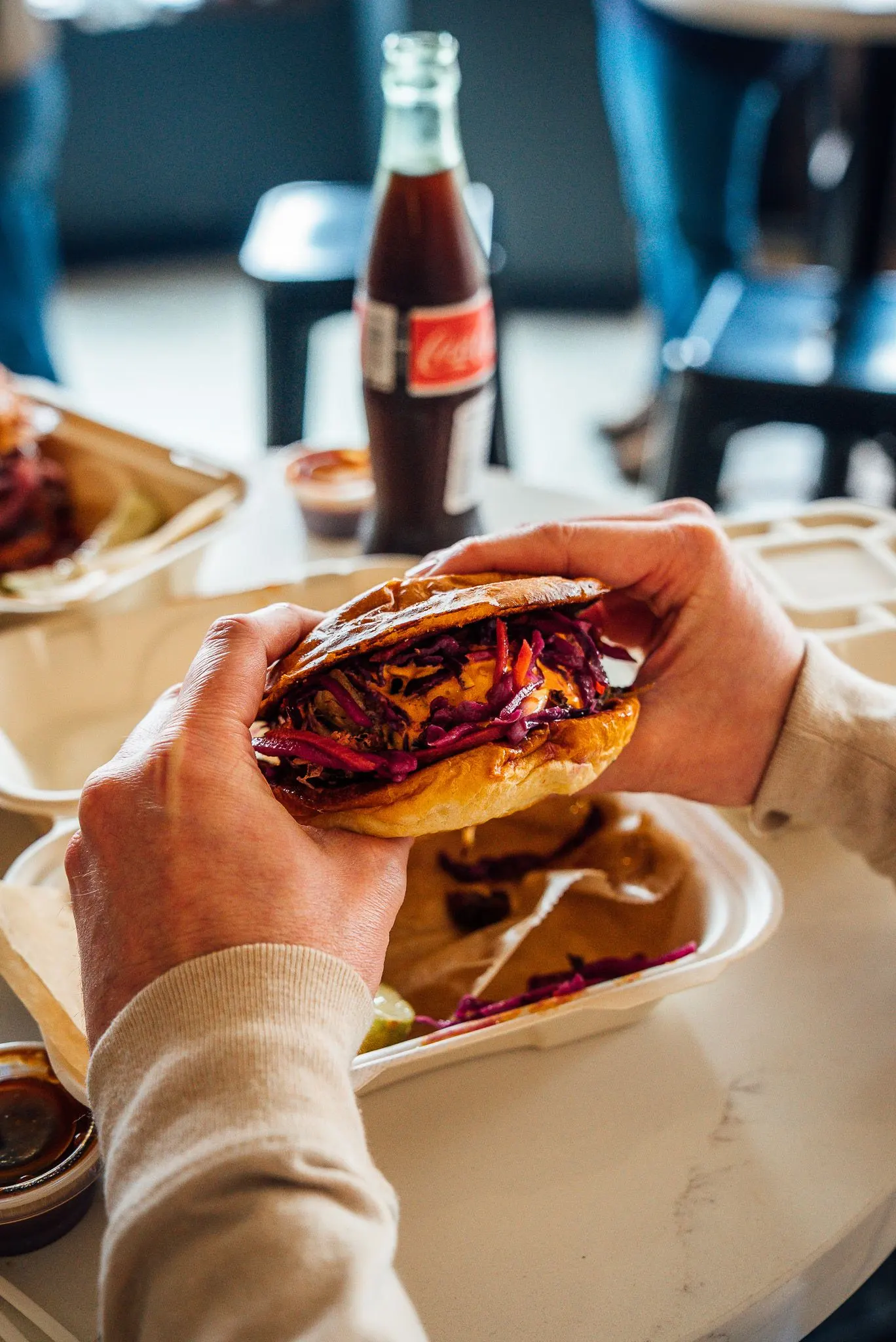 hands holding a pulled pork sandwich